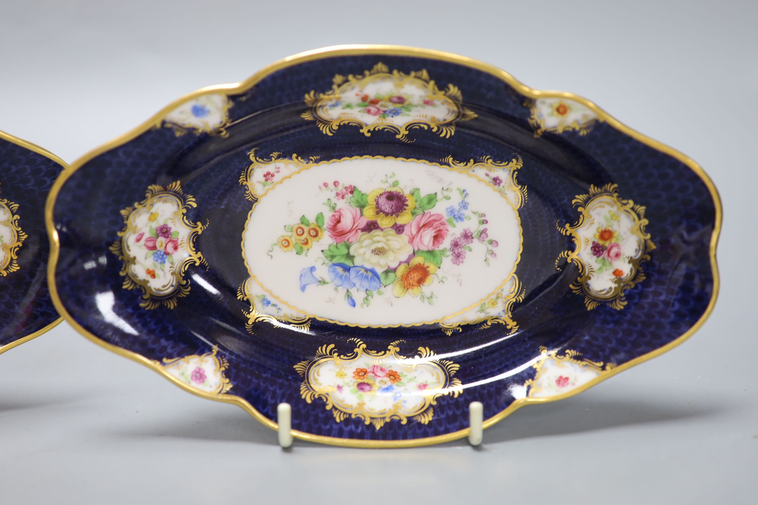 A pair of Royal Worcester blue ground floral painted dishes by E Phillips, signed date code for 1894, length 21cm